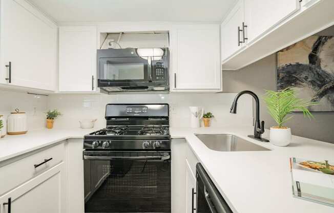 a white kitchen with a stove and a microwave