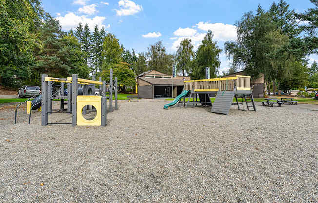 A playground with a yellow slide and a green slide.