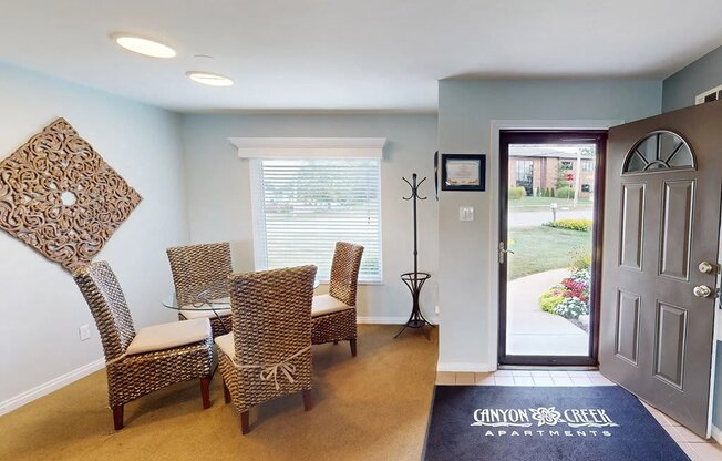 a living room with a table and chairs and a door