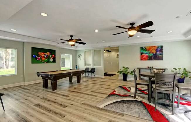 A room with a pool table and a painting on the wall.