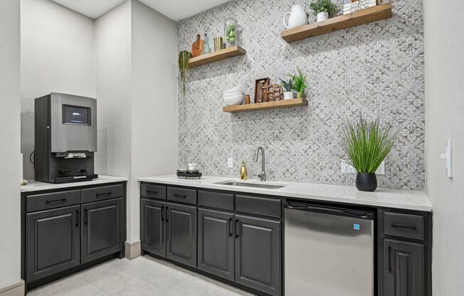 A kitchen with black cabinets and a stainless steel dishwasher.