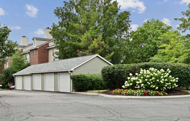 a garage with a flower garden in front of a house