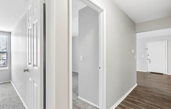 A white door is open to a room with a carpeted floor.