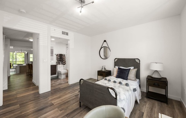 a bedroom with a bed and a chair and a bathroom