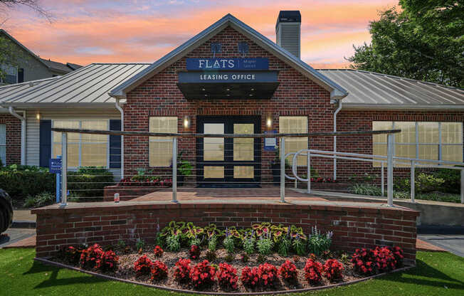 A brick building with a sign that says Flats Leasing Office.