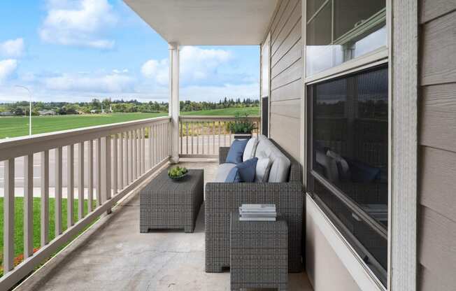 a covered porch with a couch and chairs and a tv