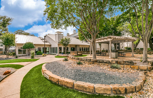 a courtyard with trees and a building in the background