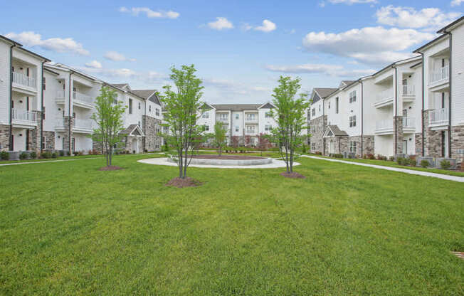 A grassy area in front of apartment buildings.