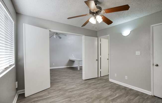 a bedroom with a ceiling fan and a closet