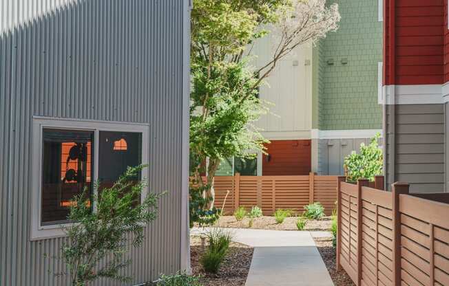 a walkway between two buildings with a fence