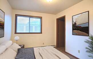 a bedroom with a bed and a window. Fargo, ND Westwood Estates Apartments