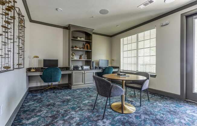 a room with a desk and chairs and a large window