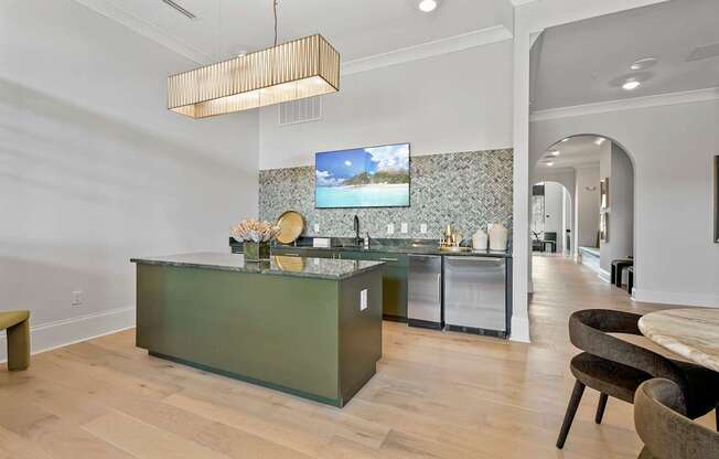 A modern kitchen with a green island and a television mounted on the wall.