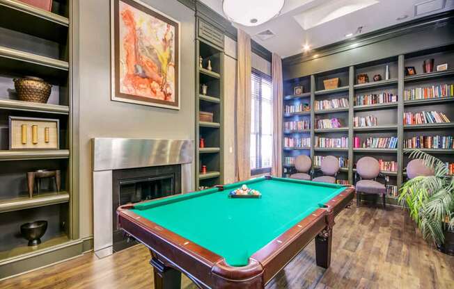 a game room with a pool table and a library