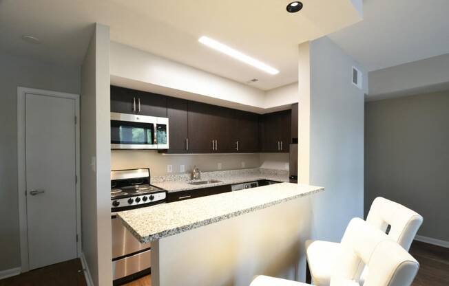 a kitchen with an island and white chairs