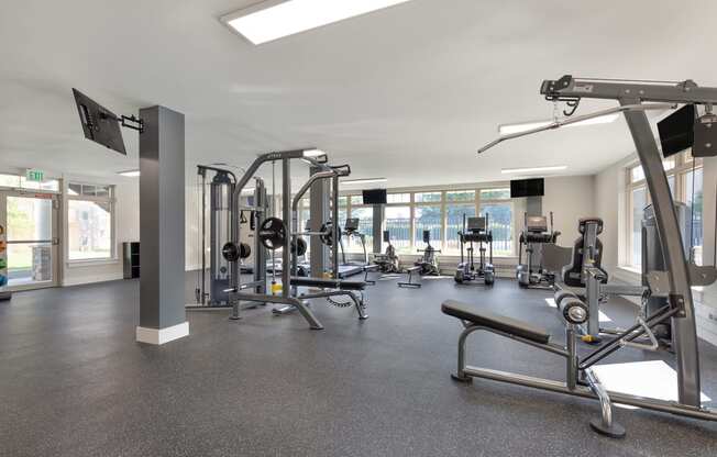 a gym with weights and other exercise equipment in a building with windows at Copper and Quarry Village, Pikesville