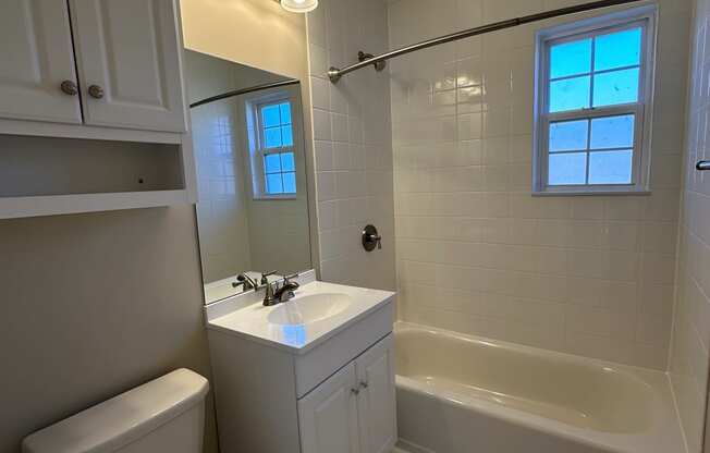 a bathroom with a toilet and a sink and a bath tub