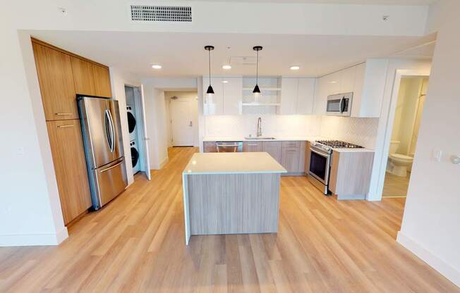 A kitchen with a wooden floor and a white ceiling.