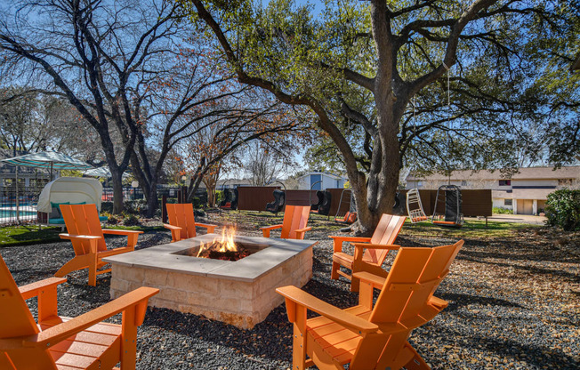 a group of orange chairs around a fire pit