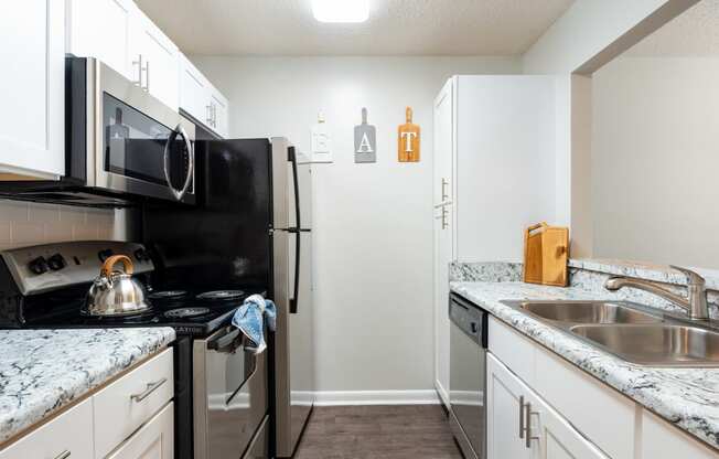 a kitchen with white cabinets and black appliances