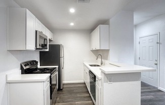 apartment kitchen with white cabinets and stainless steel appliances