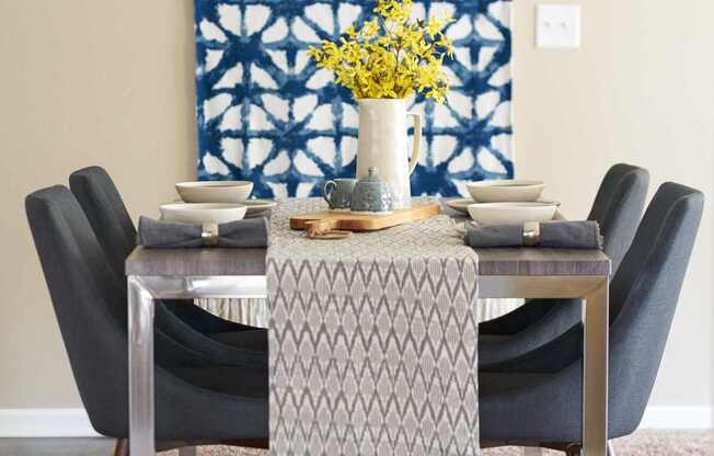 a dining room with a table and chairs and a blue and white tapestry at The Winhall of Williams Pointe Apartments, Waukee, IA, 50263