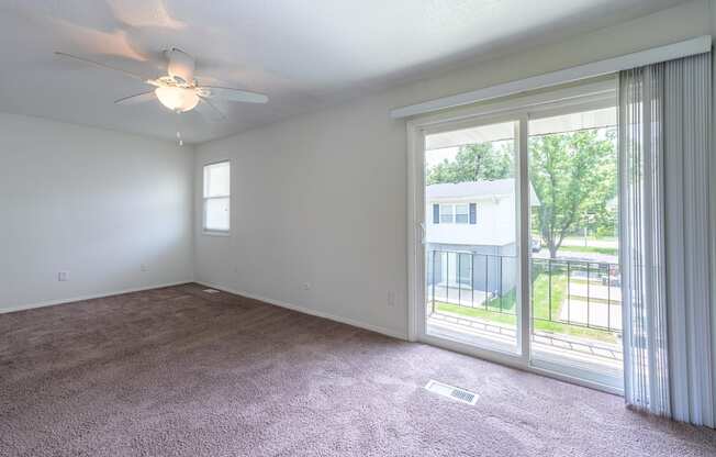 A room with a ceiling fan and sliding glass doors at Spring Creek Townhomes Apartments, Illinois 62702