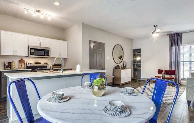 A modern kitchen with a dining table set for two.