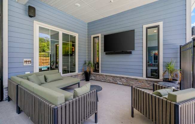 A covered patio with furniture and a flat screen tv at The Lodge at Overland, Rochester, Minnesota