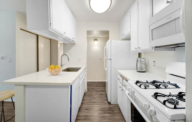 a white kitchen with white appliances and a white counter top