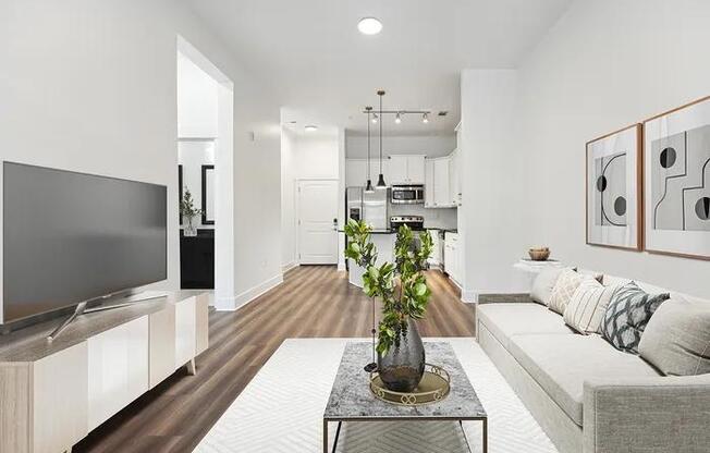A modern living room with a grey sofa and a grey television.