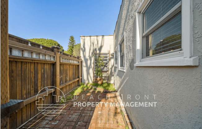 a small backyard with a wooden fence and a wooden deck