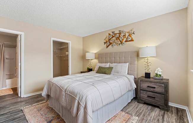 A bedroom with a large bed and a wooden dresser.