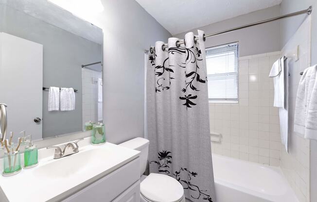 a white bathroom with a shower curtain and a sink