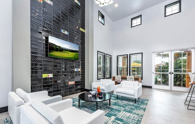 a living room with white couches and a television