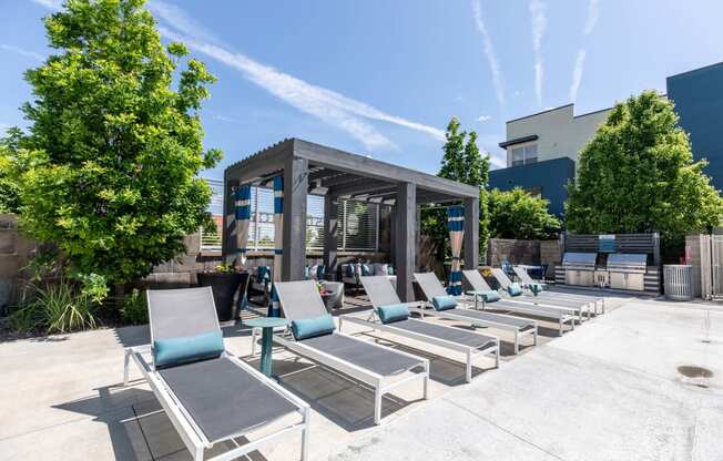 an outdoor lounge area with lounge chairs and a pergola