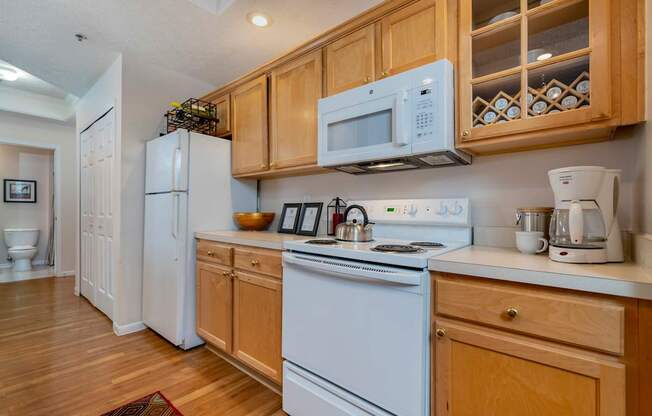 A kitchen with white appliances and wooden cabinets. at The Orchard, Dublin, OH