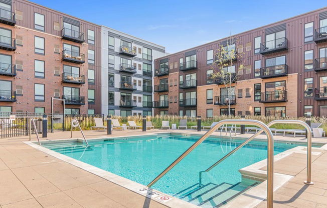 a swimming pool with an apartment building in the background