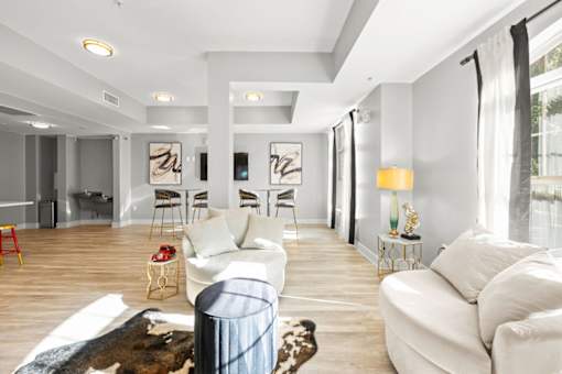 A living room with white furniture and a cowhide rug.