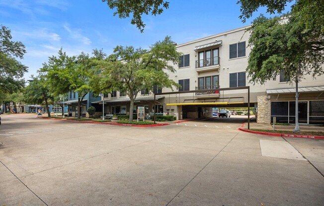 a building with a parking lot in front of it at Artisan Apartments & Shops, Austin, TX
