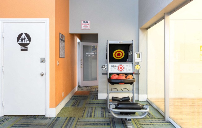 a gym with a punching bag and weights in a room with a door