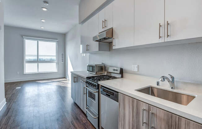 A kitchen with a stove, oven, and sink.