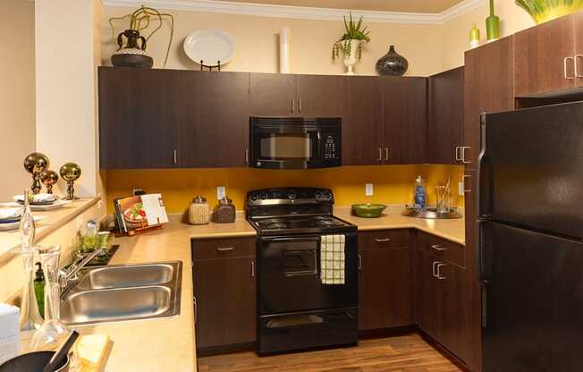 a kitchen with black appliances and brown cabinets