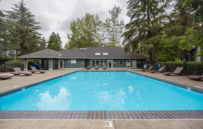 A swimming pool in front of a house with a number 5 on the ground.