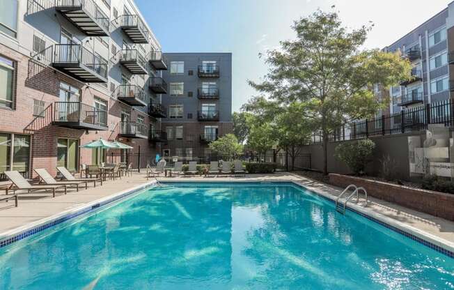 A swimming pool in a residential area surrounded by buildings.