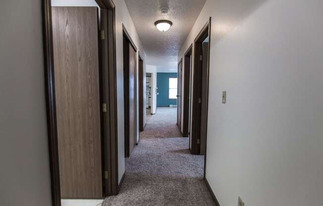 Grand Forks Primrose Apartments. A look down the hallway of an apartment with bedrooms and a bathroom