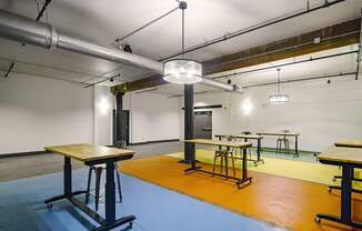 A room with tables and chairs and a blue floor.
