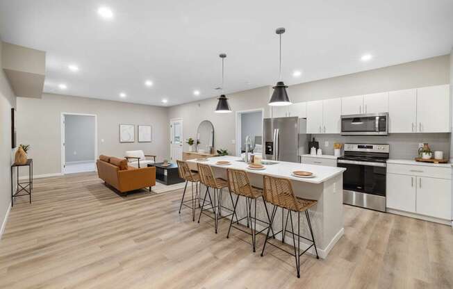 an open kitchen and living room with an island and bar stools