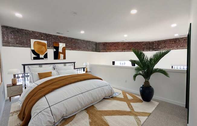 A bedroom with a large bed and a plant.