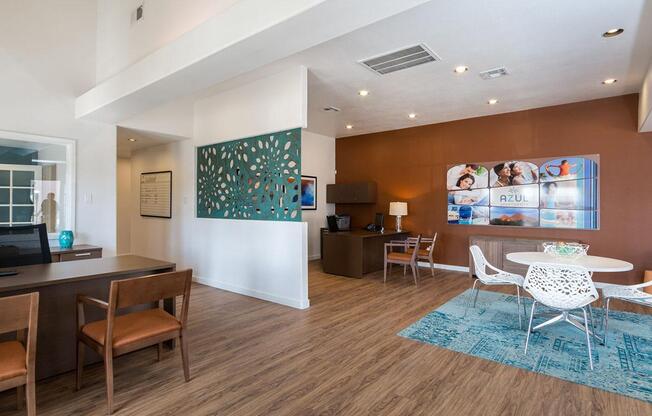 A modern living room with a brown wooden floor and white furniture.